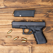 handgun and ammunition on a wood background