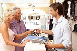 couple handing credit card to cashier to pay for items in store